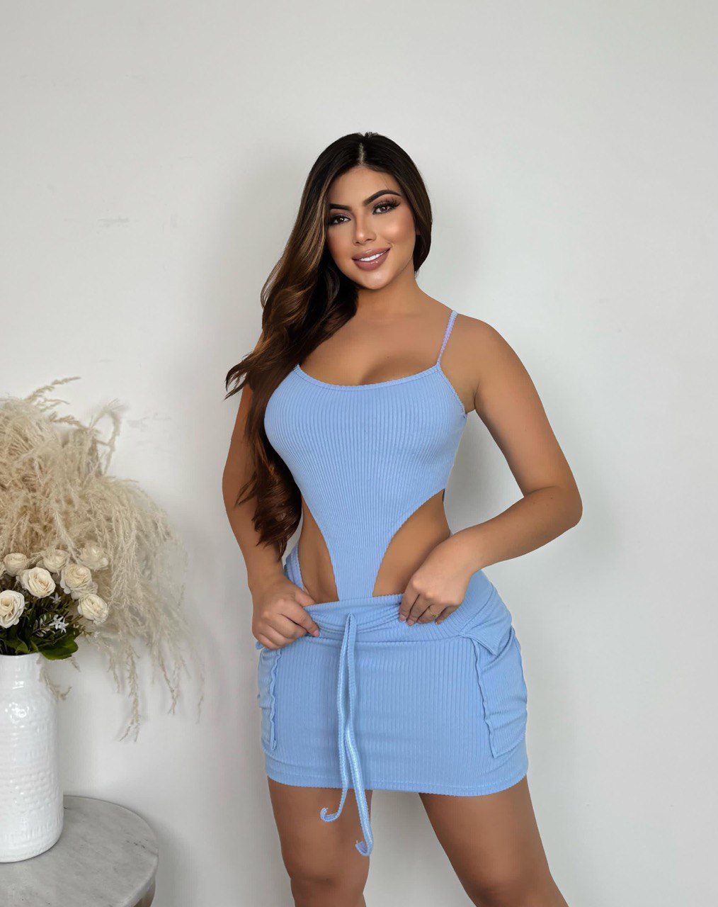Mujer usando conjunto de body y falda azul claro de tirantes, moda femenina moderna.