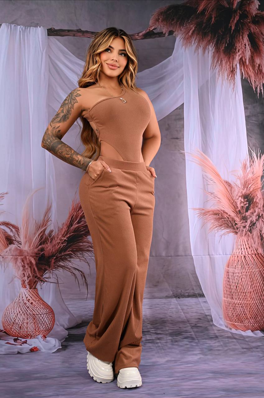 Mujer con conjunto de dos piezas marrón, pantalón acampanado y top asimétrico de canalé.