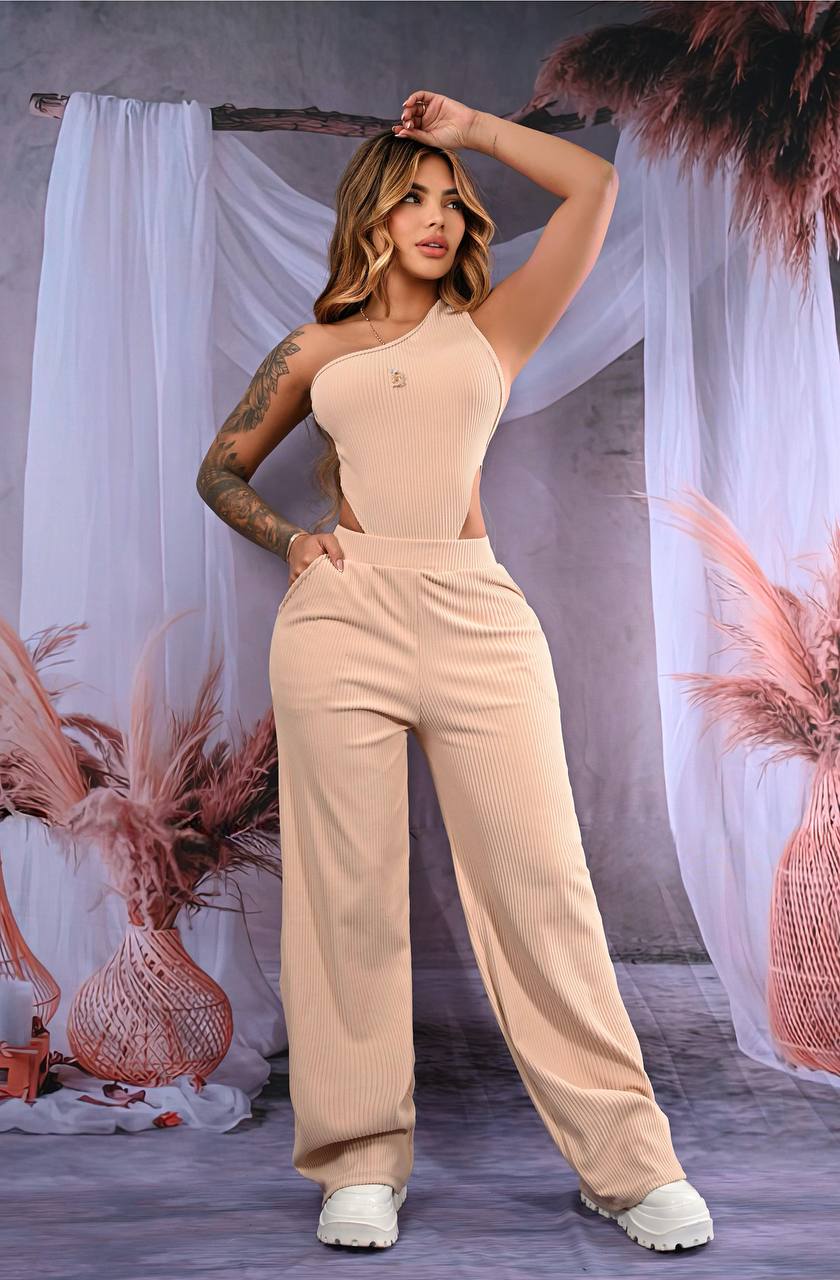 Mujer con conjunto beige de dos piezas, top asimétrico y pantalón acampanado de canalé.