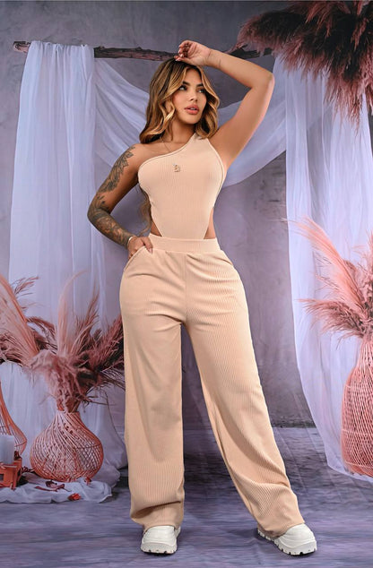 Mujer con conjunto beige de dos piezas, top asimétrico y pantalón acampanado de canalé.